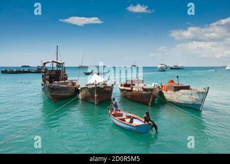 Stone Town, Sansibar, Tansania, 21. Oktober 2007: Boote und Menschen im türkisfarbenen Meer am Hafen Stockfoto