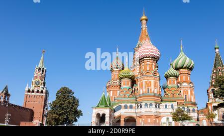 Panoramablick auf die orthodoxe Kathedrale Wassilij des Seligen (Basilius des Heiligen, Pokrovsky) und den Spasskaya-Uhrenturm in der Kremlmauer und in der Moskauer Stadt bei Sonne Stockfoto