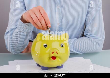 Business Womans Hand legt Münze in Sparschwein. Stockfoto