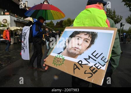 Konstanz, Deutschland. Oktober 2020. Eine Frau trägt auf ihrem Rücken ein Plakat mit der Aufschrift: 'AME Seele' neben einem Foto des Bratschers Christian Drosten. Am Nachmittag wollen sich viele Menschen rund um den Bodensee zu einer sogenannten Friedenskette zusammenschließen, die durch Deutschland, Österreich, Liechtenstein und die Schweiz führen wird. Quelle: Felix Kästle/dpa/Alamy Live News Stockfoto