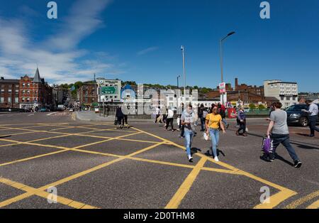 Cork City, Irland - 18. Mai 2018: Menschen überqueren die Straße am Merchant's Quay gegenüber der St. Patricks Brücke im Zentrum von Cork in einem sonnigen Sprin Stockfoto