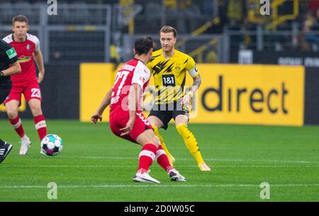 Dortmund, Deutschland. Oktober 2020. Fußball: Bundesliga, Borussia Dortmund - SC Freiburg, 3. Spieltag im Signal Iduna Park. Dortmunds Marco Reus (r) und Freiburgs Nicolas Höfler kämpfen um den Ball. Quelle: Guido Kirchner/dpa - WICHTIGER HINWEIS: Gemäß den Bestimmungen der DFL Deutsche Fußball Liga und des DFB Deutscher Fußball-Bund ist es untersagt, im Stadion und/oder aus dem Spiel aufgenommene Aufnahmen in Form von Sequenzbildern und/oder videoähnlichen Fotoserien zu nutzen oder auszunutzen./dpa/Alamy Live News Stockfoto