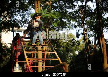 Dhaka, Bangladesch. Oktober 2020. Ein Kind, das eine Gesichtsmask trägt, sah, wie es während der Coronavirus-Pandemie im Ramna Park spielte.nach einer sechsmonatigen Pause aufgrund einer Coronavirus-Pandemie hat der Ramna Park für die Öffentlichkeit wieder geöffnet. Kredit: SOPA Images Limited/Alamy Live Nachrichten Stockfoto