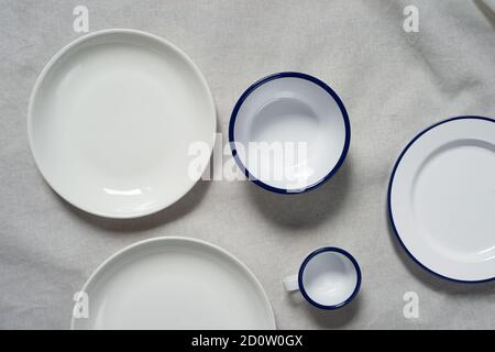 Draufsicht auf weiße Keramik Schüssel und Tasse für Essen in Getränk auf Baumwollstoff Hintergrund Stockfoto