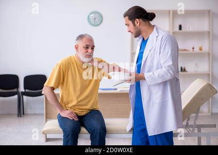 Alter Hals verletzten Mann besucht jungen Arzt Stockfoto