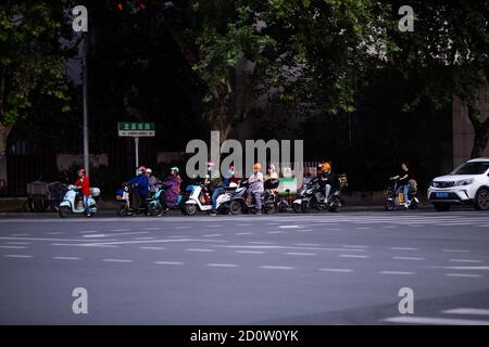 Huzhou, China 2020 September 28: Elektro-Scooter und Auto Rush Hours City Street. Autos auf der Straße im Stau auf Fußgänger Stockfoto