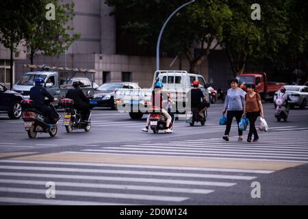 Huzhou, China 2020 September 28: Elektro-Scooter und Auto Rush Hours City Street. Autos auf der Straße im Stau auf Fußgänger Stockfoto