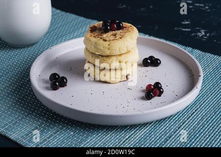 Hüttenkäse Pfannkuchen mit Waldbeeren auf dem Teller Stockfoto