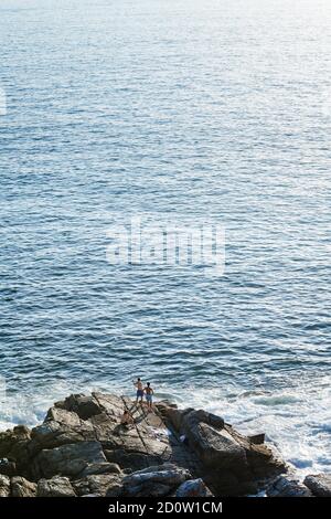 PORTONOVO, SPANIEN - 14. AUGUST 2020: Drei junge Fischer fischen an einem ruhigen klaren Abend in den Rias Baixas in Galicien, Spanien. Stockfoto