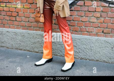 Mailand, 24. September 2020: Model trägt eine orangene Hose und ein Paar weiße Stiefel Stockfoto