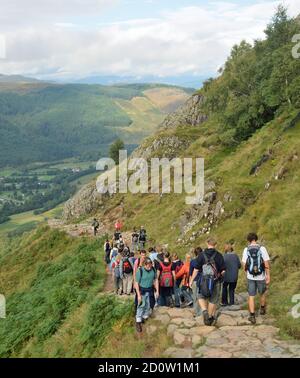 Menschen zu Fuß auf den unteren Hängen des Tourist Path, der zum Gipfel des Ben Nevis führt, Großbritanniens höchsten Berg. Stockfoto