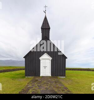 Traditionelle schwarze Kirche mit weißer Holztür und Steinmauer, Holzkirche Búðakirkja, Búðir, Budir, Snæfellsnes Halbinsel, Island, Europa Stockfoto