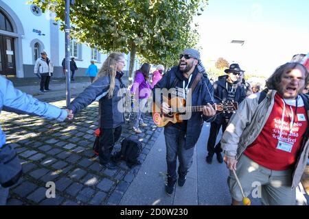 Konstanz, Deutschland. Oktober 2020. Viele Menschen bilden am Ufer des Bodensees eine Kette des Friedens, während eine Musikgruppe daran vorbeiläuft. Die sogenannte Peace Human Chain wird durch Deutschland, Österreich, Liechtenstein und die Schweiz rund um den Bodensee führen. Quelle: Felix Kästle/dpa/Alamy Live News Stockfoto