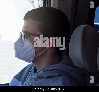 Junger Co-Pilot in einem Fahrzeug mit dem covid19-Virenschutz Maske Stockfoto
