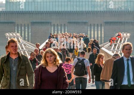 Menschen, die die Millennium-Fußgängerbrücke über die Themse in London überqueren. Blick nach Süden mit Tate Modern Galerie im Hintergrund. Stockfoto