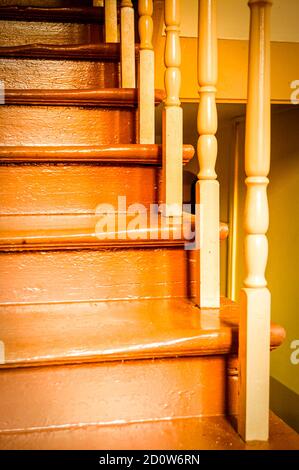 Vertikale Aufnahme einer alten hölzernen Treppe an einer Halle Braun gestrichen Stockfoto