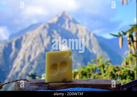 Käsesammlung, französischer emmental de savoie Käse mit runden Löchern, serviert im Freien in der Savoyer Region, mit Berggipfeln im Sommer auf dem Backgrou Stockfoto