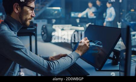 Professional Automotive Graphic Designer arbeitet an Concept Car Render Mit einem Stylus Pen in einem innovativen Hightech-Labor Mit einem Prototyp Auto Stockfoto