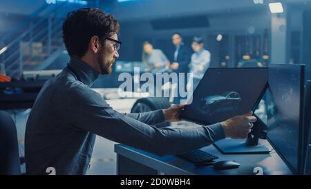 Professional Automotive Graphic Designer arbeitet an Concept Car Render Mit einem Stylus Pen in einem innovativen Hightech-Labor Mit einem Prototyp Auto Stockfoto