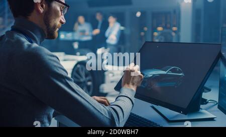 Professional Automotive Graphic Designer arbeitet an Concept Car Render Mit einem Stylus Pen in einem innovativen Hightech-Labor Mit einem Prototyp Auto Stockfoto
