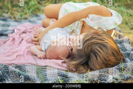 Die ältere Schwester hält das Neugeborene in ihren Armen. Selektiver Fokus. Menschen. Stockfoto