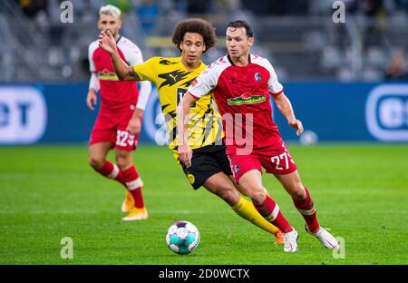 Dortmund, Deutschland. Oktober 2020. Fußball: Bundesliga, Borussia Dortmund - SC Freiburg, 3. Spieltag im Signal Iduna Park. Freiburgs Nicolas Höfler (r) und Dortmunds Axel Witsel kämpfen um den Ball. Quelle: Guido Kirchner/dpa - WICHTIGER HINWEIS: Gemäß den Bestimmungen der DFL Deutsche Fußball Liga und des DFB Deutscher Fußball-Bund ist es untersagt, im Stadion und/oder aus dem Spiel aufgenommene Aufnahmen in Form von Sequenzbildern und/oder videoähnlichen Fotoserien zu nutzen oder auszunutzen./dpa/Alamy Live News Stockfoto