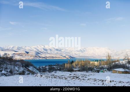 Charvak Bergsee in Usbekistan an einem verschneiten frostigen Tag, umgeben von den Tien Shan Bergen Stockfoto