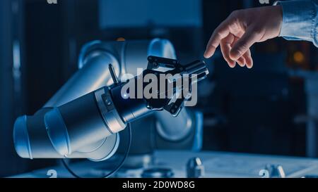 Futuristischer Roboterarm berührt menschliche Hand in der Menschheit und Künstliche Intelligenz verbindende Geste. Bewusste Technik Trifft Auf Menschlichkeit. Konzept Stockfoto