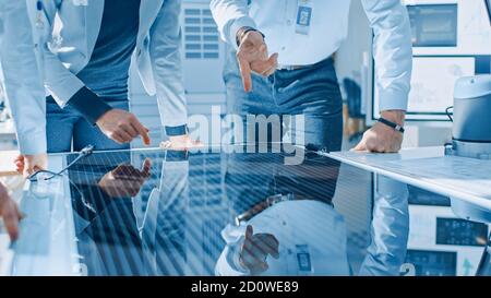 Team-Treffen von Ingenieuren für erneuerbare Energien, die an einem innovativen, effizienteren Solarpanel-Batteriekonzept arbeiten. Gruppe von Spezialisten versammelt Stockfoto