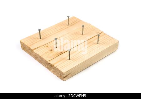 Demonstration von Metallnägeln in Holzbretter auf weißem Hintergrund getrieben. Stockfoto