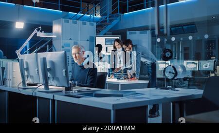 Vielfältiges internationales Team von Industrieingenieuren und Wissenschaftlern, die im Labor für Industrieentwicklung arbeiten. Gruppe von Fachleuten Stockfoto