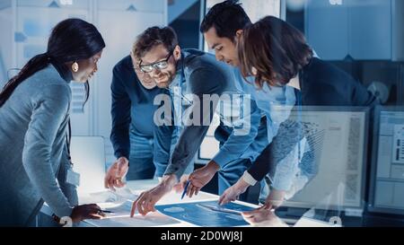 Ingenieure treffen in Technology Research Laboratory: Ingenieure, Wissenschaftler und Entwickler versammelten sich um beleuchteten Konferenztisch, reden und Stockfoto