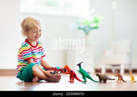 Kinder spielen mit bunten Spielzeug Dinosaurier. Pädagogische Spielwaren für Kinder. Kleinen Jungen lernen, Fossilien und Reptilien. Kinder spielen mit Dinosaurier Spielzeug. Evol Stockfoto