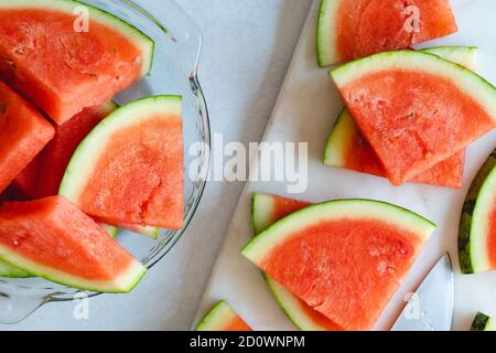 Wassermelone Scheiben auf einem Teller und Schneidebrett, Nahaufnahme von oben Stockfoto
