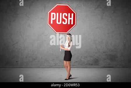 Junge Geschäftsmann hält Straßenschild mit PUSH-Inschrift, neue Regeln Konzept Stockfoto