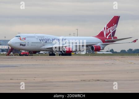 Flughafen London Heathrow, London, Großbritannien. Oktober 2020. Der Schaden für die Reisebranche durch die Coronavirus-Pandemie hat den Ausscheiden vieler Flugzeuge der Fluggesellschaft Boeing 747 'Jumbo Jet' vorgezogen. Sowohl British Airways als auch Virgin Atlantic haben in Heathrow ein paar pensionierte Flugzeuge im Lager, die nach und nach für Schrott oder andere Zwecke unterwegs sind. Virgin 747 Registrierung G-VROM, links heute auf einen 'Boneyard' in Pinal, Arizona, und hinterließ einen, G-VROS, der mit 'Forever Young' unter dem Cockpit bemalt wurde. Früher 'English Rose' Stockfoto