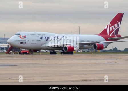 Flughafen London Heathrow, London, Großbritannien. Oktober 2020. Der Schaden für die Reisebranche durch die Coronavirus-Pandemie hat den Ausscheiden vieler Flugzeuge der Fluggesellschaft Boeing 747 'Jumbo Jet' vorgezogen. Sowohl British Airways als auch Virgin Atlantic haben in Heathrow ein paar pensionierte Flugzeuge im Lager, die nach und nach für Schrott oder andere Zwecke unterwegs sind. Virgin 747 Registrierung G-VROM, links heute auf einen 'Boneyard' in Pinal, Arizona, und hinterließ einen, G-VROS, der mit 'Forever Young' unter dem Cockpit bemalt wurde. Früher 'English Rose' Stockfoto