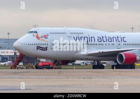 Flughafen London Heathrow, London, Großbritannien. Oktober 2020. Der Schaden für die Reisebranche durch die Coronavirus-Pandemie hat den Ausscheiden vieler Flugzeuge der Fluggesellschaft Boeing 747 'Jumbo Jet' vorgezogen. Sowohl British Airways als auch Virgin Atlantic haben in Heathrow ein paar pensionierte Flugzeuge im Lager, die nach und nach für Schrott oder andere Zwecke unterwegs sind. Virgin 747 Registrierung G-VROM, links heute auf einen 'Boneyard' in Pinal, Arizona, und hinterließ einen, G-VROS, der mit 'Forever Young' unter dem Cockpit bemalt wurde. Früher 'English Rose' Stockfoto