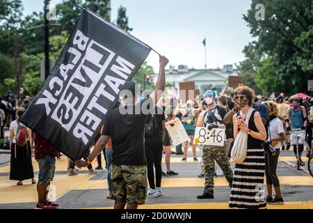 Protestler hält Black Lives Matter Flagge bei Protest in DC Stockfoto