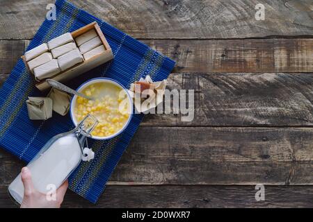 Mazamorra mit Guava-Sandwich und Milchflasche auf rustikalem Holzboden Latin Food-Konzept. Speicherplatz kopieren. Stockfoto