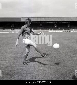 1960s, historisch, Torwart mit Ball in den Händen, Charlton Athletic Footall Club, Pre-Season Training, Southeast London, England, Großbritannien. In dieser Zeit wurde Fußball auf dem Gelände mit traditionellen Terrassen gespielt, wo Fußballfans standen, um das Spiel zu beobachten, einige waren offen und einige waren überdachte Stände, wie man hier sehen kann. Stockfoto