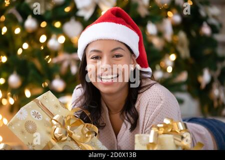 Portrait der lächelnden Biracial Frau in Santa hat Stockfoto