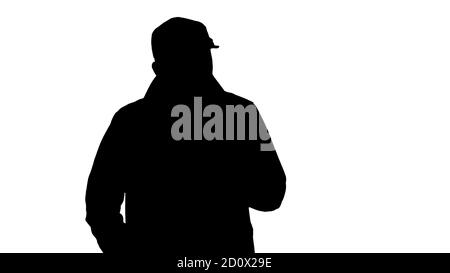 Silhouette EIN positiver bärtiger Rüde in einem Trenchcoat gekleidet Gehen Stockfoto