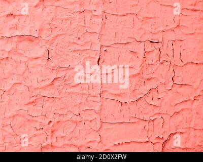 Trendfotografie zum Thema der aktuellen Farben für diese Saison - ein Farbton von Orange. Alte helle Holzwandpaneel sind mit rissiger Farbe bedeckt. Stockfoto