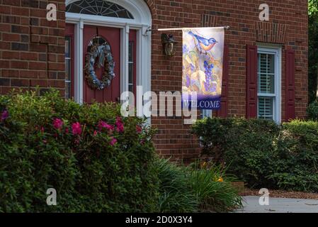 Willkommensflagge am Eingang zu einem gehobenen Ziegelhaus in Lilburn (Metro Atlanta), Georgia. (USA) Stockfoto