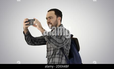 Hübscher junger Mann, der Rucksack trägt und ein Foto von nimmt Er Stockfoto