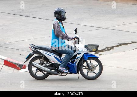 SAMUT PRAKAN, THAILAND, JUNI 26 2020, der Mototaxi-Fahrer in einer blauen Weste fährt auf der Straße. Stockfoto