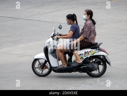 SAMUT PRAKAN, THAILAND, JULI 25 2020, zwei Frauen mit Gesichtsmaske fahren auf dem Motorrad auf der Straße. Stockfoto