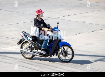 SAMUT PRAKAN, THAILAND, JULI 29 2020, Frau mit Gesichtsmaske fährt ein Motorrad Stockfoto