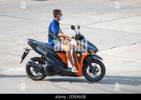 SAMUT PRAKAN, THAILAND, JULI 29 2020, EIN Mann mit Gesichtsmaske fährt ein Motorrad Stockfoto